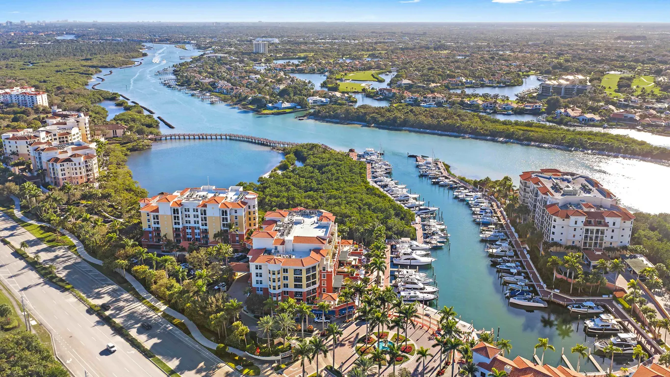 Aerial view of Jupiter Yacht Club in Palm Beach County featuring waterfront condos, marina with boats, and Intracoastal views